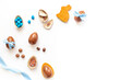 Easter background. Chocolate Easter eggs in blue ribbon with bunny cookies