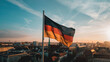 German Flag The black red and gold flag of Germany flying high over a bustling cityscape representing unity democracy and the strength of the nation