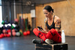Sportive mature woman using phone on a cross training gym