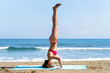 Calm lady balancing in headstand on seashore