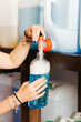 © GALDRIC - Close-Up of a Female Customer Refilling a Detergent Bottle at a Zero Waste Store