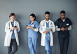 © peopleimages.com - Nurses, doctors and row by wall with technology for waiting with social media, online and networking for medical education. People, diversity and in line with internet for interview or meeting.