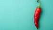 Pod of fresh red chili pepper with green stalk over light blue studio background. Organic spicy seasoning concept. 