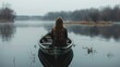 A woman with long hair stands bowing her head in a small boat on a calm lake, a picture of solitude