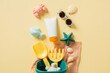 Sunscreen tube mockup with baby sand beach toys and sunglasses on pastel beige table. Top view. Flat lay.