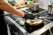 © pavel siamionov - Professional chef skillfully sautéing sliced mushrooms in a pan on a stove, capturing the essence of culinary art.
