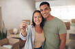 © peopleimages.com - Portrait, couple and smile in new home with keys for moving in, satisfied and confident with ownership. House, relationship and happy with unpacking furniture, excited and positive with property