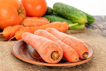 Canvas Print - Peeled sweet carrots on the table with vegetables.	