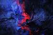 Indigo and scarlet blend abstractly on a black canvas.