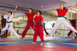 © JackF - Cheerful teenage children jumping with their instructor during group class at gym