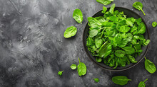 A Bowl Of Green Spinach Leaves On A Grey Background
