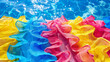 A colorful array of ruffled fabric is floating on the surface of a pool