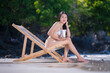 Sexy woman with bikini used applying sun cream on body is sun block skin protection and body care cream on beach summer holiday vacation .	