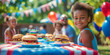 Portrait of a small African American boy sitting at the dining table. The child eats delicious burgers and other national food. The concept of celebrating Independence Day in America on July 4th.