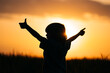 Silhouette of positive little boy with hands sign like, thumbs up gesture. Happy