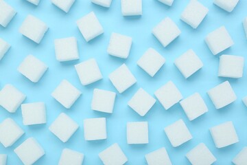 Wall Mural - White sugar cubes on light blue background, top view