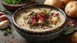 A clean and modern shot of a bowl of creamy potato leek soup with crispy bacon garnish.