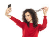 Happy curly woman making selfie photo on a white background