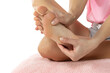 Beauty women's  bare foot with smooth skin in the studio, foot care and self-massage, unrecognizable person