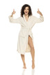 young happy woman posing in bathrobe and showing thumbs up on a white background