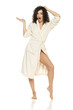 young happy woman posing in bathrobe and holding imaginary objeect on a white background