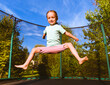 Happy kid jumping on trampoline outdoors on sunny summer day