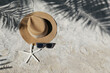 Summer vibes. Straw hat and sunglasses on a sandy beach. Copy space for text.