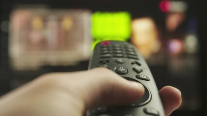 Woman with remote in hand switching channels, smart tv technology internet video content, screen with media content at the background close up shot.