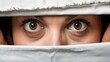   A close-up of eyes hidden beneath a white sheet, surrounded by more white fabric
