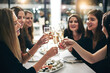 Women, friends and celebration with champagne in restaurant for toast, sushi and dinner together. Female people, party and sparkling wine for cheers, happiness and fine dining for girls night out