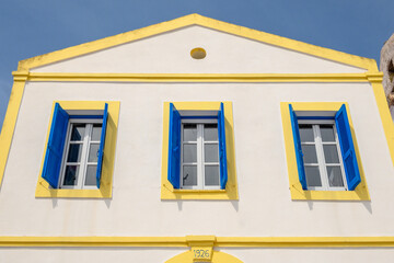 Wall Mural - Greek whitewashed building with blue shutters in Nikia village. Nisyros island, Greece