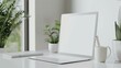 © Nijat - A simple and elegant workspace with a laptop, a cup, a plant, and a notebook. The perfect place to work on your next project.
