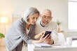 © Studio Romantic - Smartphone usage among older adults, senior couple learn interacting with phone digital information online, nice elderly people, old pair family at home together, keep in touch with family and friends