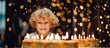 Child in white top gazes at glowing candles on cake
