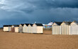 Beach cabins on the beach at Ouistreham with a very dark sky. in the Calvados department in the Basse-Normandie region in northwestern France.