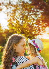 Wall Mural - Pretty smiling girl relaxing outdoor with the mother. Poster.