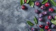 Fresh plums scattered on a textured dark background