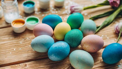 Wall Mural - top view of the children painting easter eggs together on a wooden table children spend time together and crafts at a colorful and messy home workstation