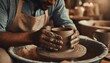 © Lucia - dirty male hands sculpt mug with ceramic clay on potter s wheel