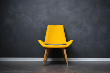 Stylish bright yellow chair against a dark gray wall. Stylish chair on wall background, copy space, fashionable interior