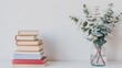 © horizon - A minimalist design with a white background, an empty desk holding a stack of books, and a vase of eucalyptus leaves. For Design, Background, Cover, Poster, Banner, PPT, KV design, Wallpaper