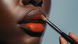 A dark-skinned girl puts lipstick on her lips. Close-up of a girl doing lip makeup. Applying lipstick with a brush on the lips. Red lipstick.