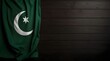 Flag of Pakistan fabric on dark wood .Generative AI