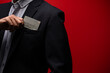 Close up hand of businessman holding credit card isolated red background.