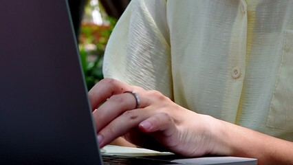 Wall Mural - young woman's hands typing on a laptop