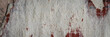 Torn old faded paper wallpaper with a retro pattern. Tattered scraps of paper on the wall. Wide panoramic texture for background and design.