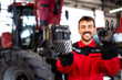Mechanic holding spare parts for tractor service.
