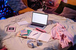 High angle view of laptop, headphones, textbooks and notebooks on bed in teenagers room interior, copy space