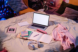 Fototapeta  - High angle view of laptop, headphones, textbooks and notebooks on bed in teenagers room interior, copy space
