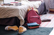 No people shot of backpack, yellow sneakers and books on floor in teenagers bedroom, copy space